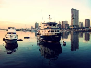 Boats in river at sunset