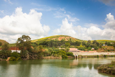 Scenic view of lake by trees against sky