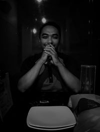 Full length portrait of a young man drinking glass in restaurant