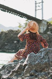 Young woman in dress and felt hat on horochowski bridge on katun river, altai