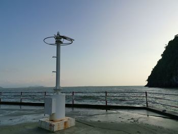 Street light on beach against clear sky during sunset