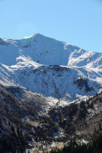 Scenic view of snowcapped mountains against clear blue sky