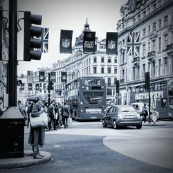 Cars on city street against sky