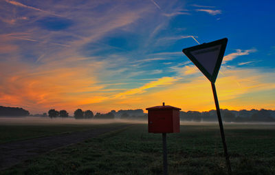 Lifeguard hut on field against sky during sunset