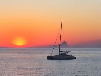 Sailboat in sea at sunset