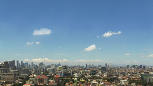 Aerial view of buildings in city against sky