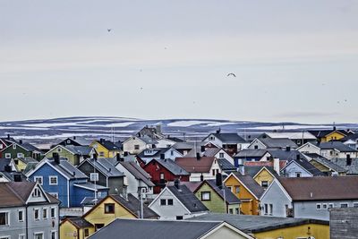 Close-up of houses by sea against sky