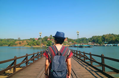 Traveler walking on mon bridge, the longest handmade wooden bridge in thailand, sangkhlaburi town