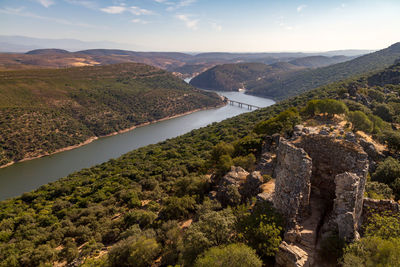 Scenic view of river by mountains against sky