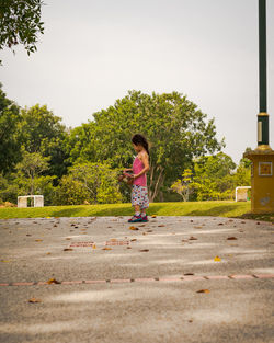 Child riding skateboard in the park. little girl learning to ride skate board. active outdoor sport.