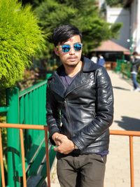 Portrait of young man wearing sunglasses standing outdoors