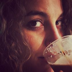 Close-up portrait of a serious young woman drinking glass