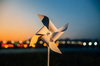 Close-up of toy on land against sky during sunset
