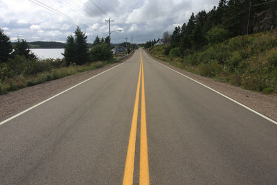 Road amidst trees against sky