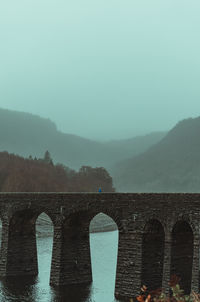 Bridge over mountains against sky