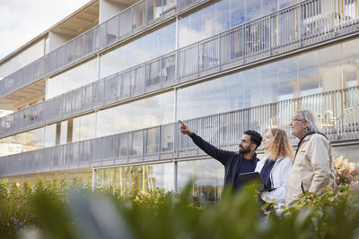 Men and woman with laptop looking at buildings