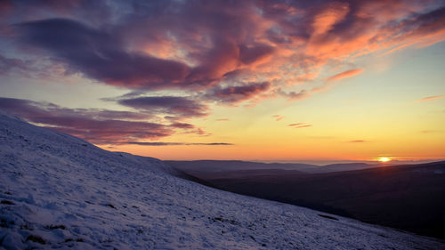 Scenic view of snowcapped mountains against sky during sunset