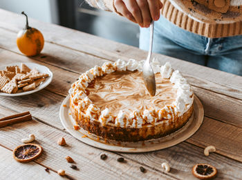 Close-up of woman baking cake. whipped cream, pumpkin pie, caramel.