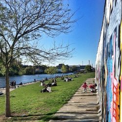 People walking on footpath by river