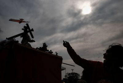 Low angle view of silhouette statue against sky