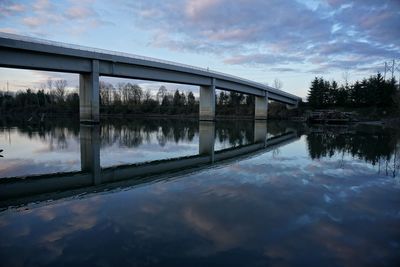 A pedestrian bridge casts its reflection on the glassy waters of the columbia slough in portland, or