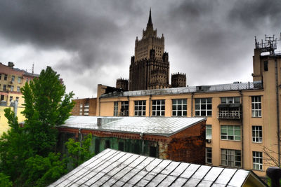 Buildings in city against cloudy sky