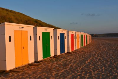 Row of beach huts against clear sky