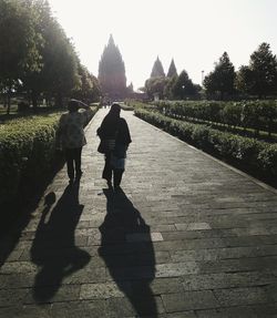 Rear view of people walking on road