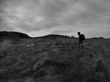 Full length of man walking on field against sky