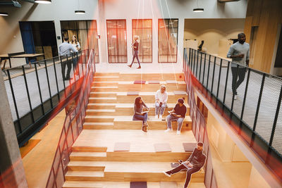 Business people sitting on stairs in office and working