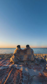 Two people cozying up under a blanket in the winter