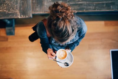 Directly above shot of woman holding cappuccino