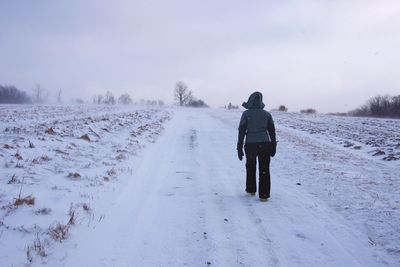 Man walking on snow covered field