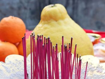 Close-up of incenses and fruits in temple