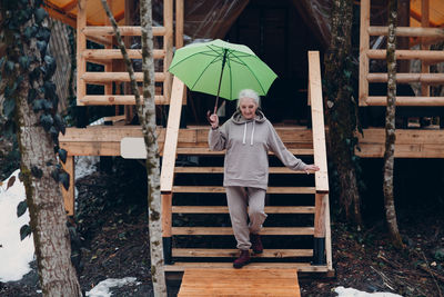 Woman walking while holding umbrella