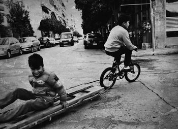 Boy riding bicycle on city street
