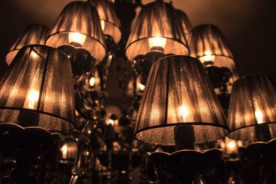 Low angle view of illuminated lamp hanging at night