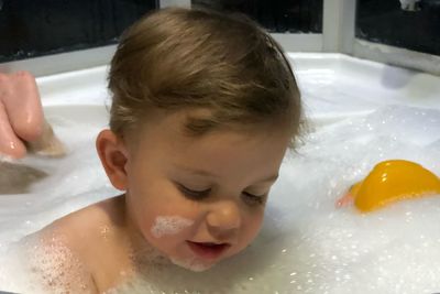 Portrait of baby boy in bathtub at home