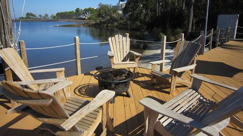 High angle view of empty chairs and table by sea
