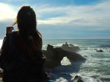 Rear view of woman looking at sea against sky