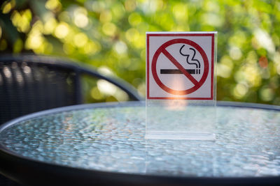 Close-up of no smoking sign on table