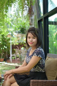 Portrait of young woman sitting on sofa outdoors