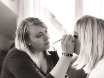 Close-up of artist applying make-up on woman face