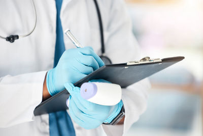 Midsection of doctor examining patient in hospital