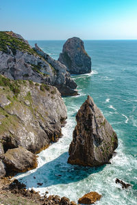 Rocks on sea shore against sky
