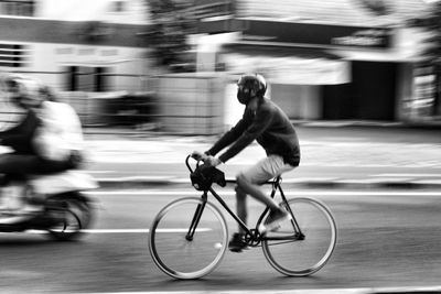Man riding bicycle on street in city
