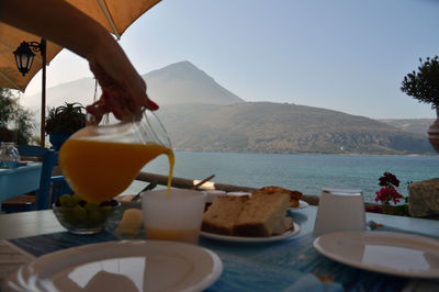 Close-up of breakfast served on table against sea