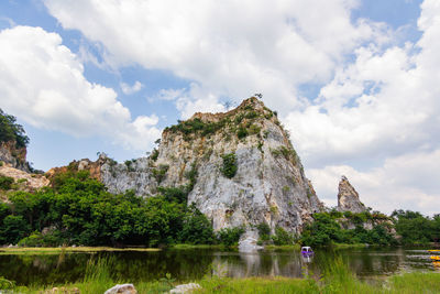 Scenic view of lake by rock formation against sky