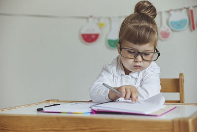 Charming child plays pretending to be a teacher