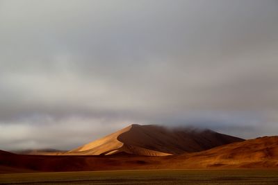 Scenic view of arid landscape against sky